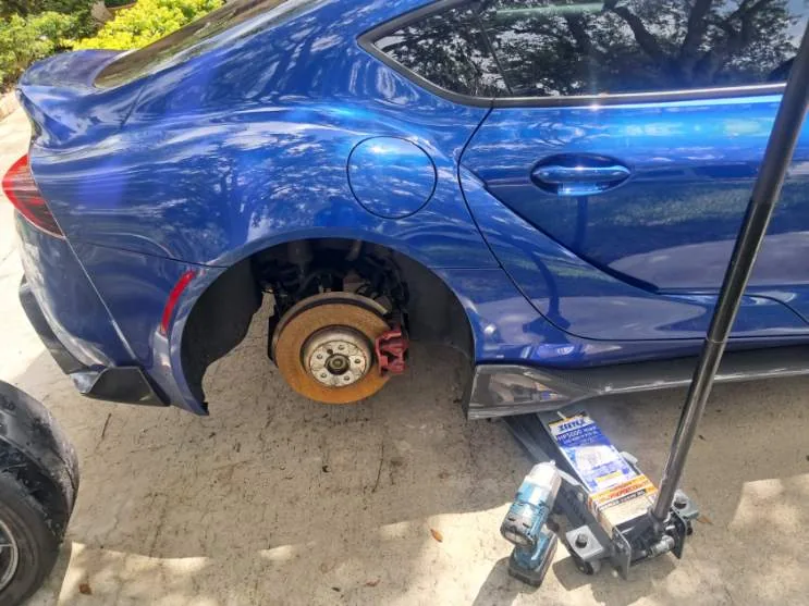 Wheel off a blue sports car during a driveway tire job by Fredoo Mobile Tire Shop in Fort Lauderdale, FL