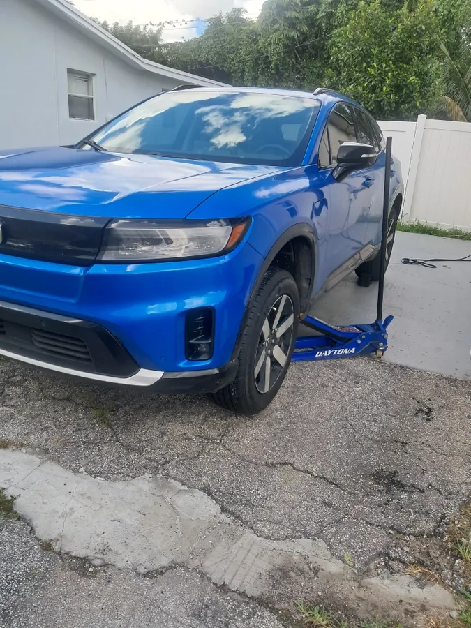 Blue SUV on a jack for a mobile tire service in Fort Lauderdale, FL - Fredoo Mobile Tire Shop