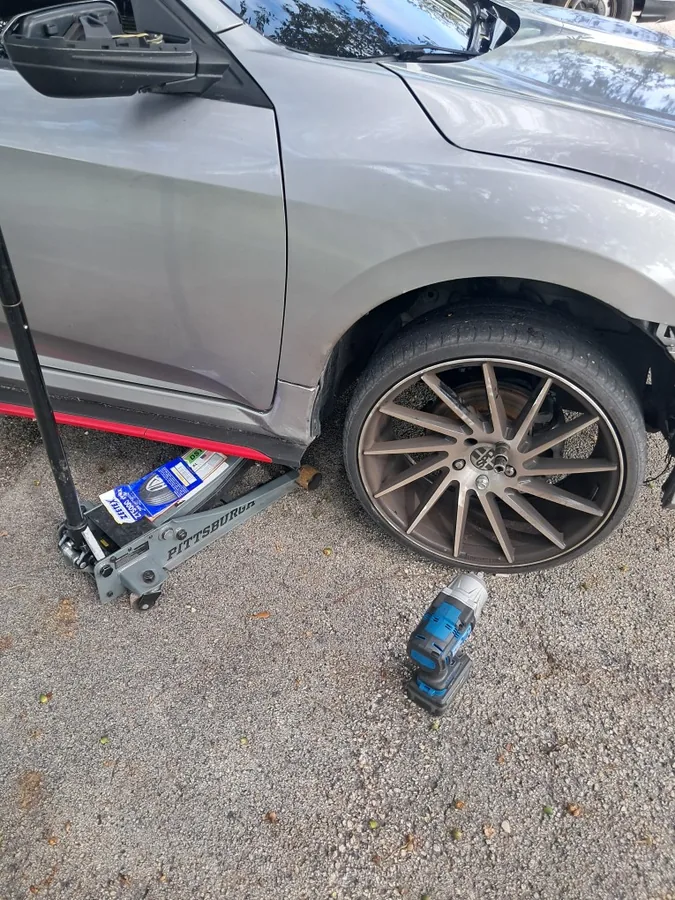 Wheel back on a silver sedan after a mobile tire job by Fredoo Mobile Tire Shop